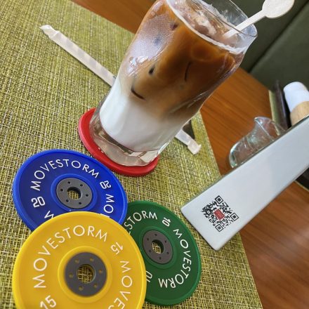 Movestorm bumper plate rubber coaster merchandise in Olympic-inspired colors.